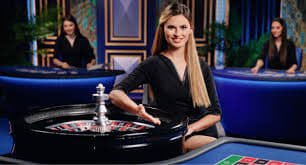 Host profesional memandu setiap sesi dengan komunikasi langsung Host live dealer Crazy Time di studio domino88 dengan peralatan broadcast profesional